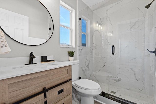 bathroom featuring vanity, an enclosed shower, and toilet