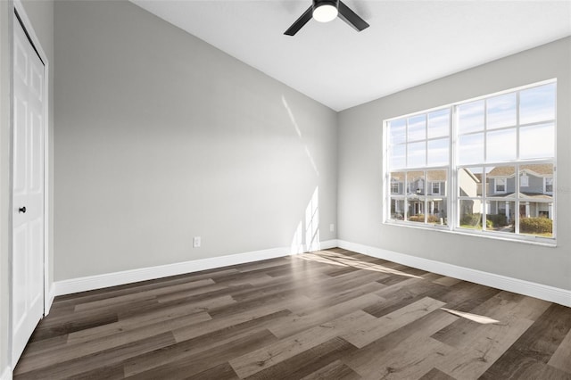 spare room with dark hardwood / wood-style flooring, ceiling fan, and plenty of natural light