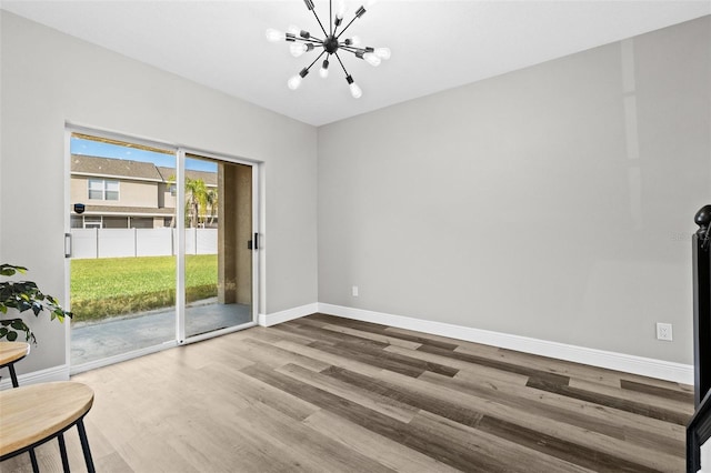 unfurnished room with hardwood / wood-style floors and a chandelier