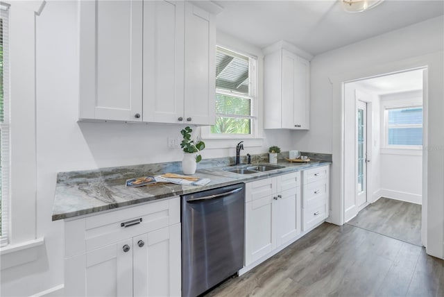 kitchen featuring dishwasher, sink, light hardwood / wood-style floors, light stone counters, and white cabinetry