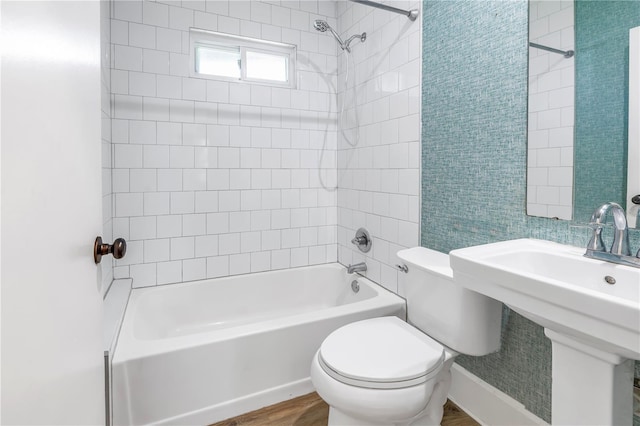 full bathroom featuring hardwood / wood-style flooring, toilet, sink, and tiled shower / bath