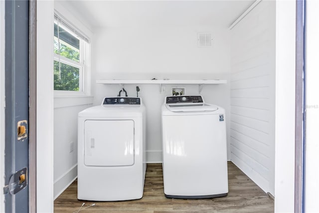 laundry area with washing machine and clothes dryer and dark hardwood / wood-style flooring