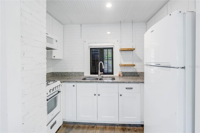 kitchen with white appliances, dark wood-type flooring, white cabinets, sink, and dark stone countertops