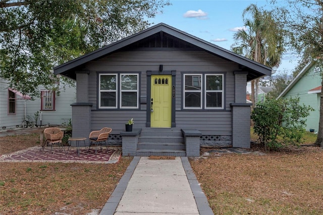 bungalow-style home with a patio and a front lawn