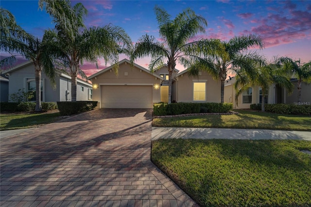 view of front of home with a garage and a yard