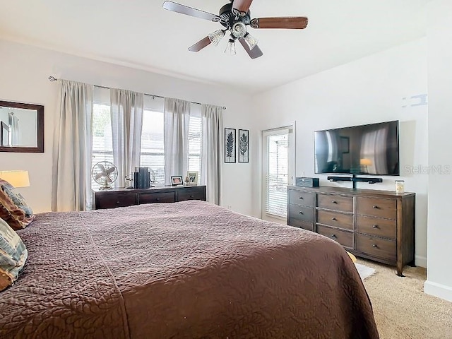 bedroom with a ceiling fan, light carpet, and baseboards