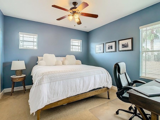 bedroom with a ceiling fan, light colored carpet, and baseboards