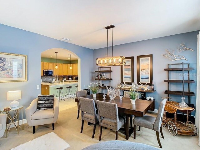 dining area with arched walkways, visible vents, and baseboards