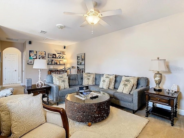 living area featuring baseboards, visible vents, arched walkways, and a ceiling fan