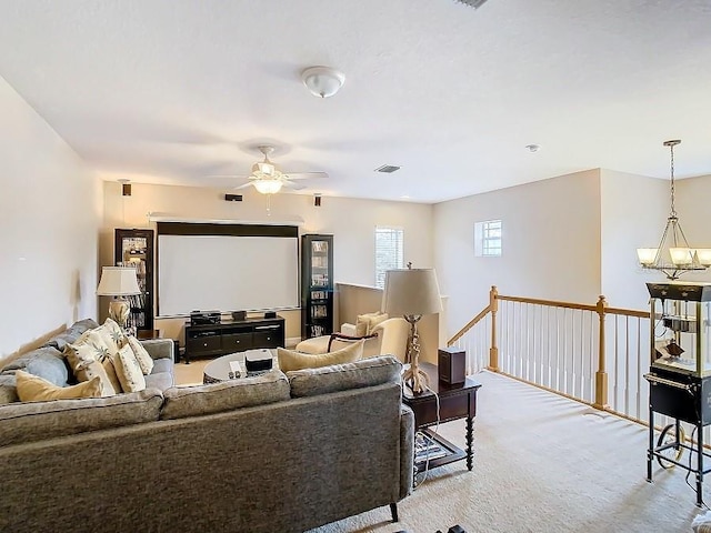 living room featuring visible vents, ceiling fan with notable chandelier, and light colored carpet