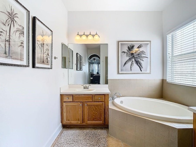 bathroom with tile patterned flooring, a bath, and vanity