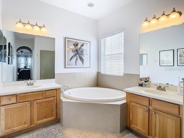 full bathroom with tile patterned flooring, a sink, a bath, and a healthy amount of sunlight