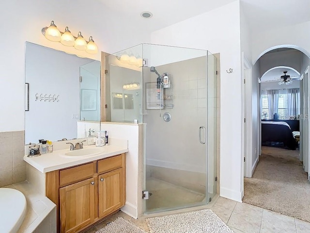 full bathroom featuring a tub to relax in, connected bathroom, vanity, a shower stall, and tile patterned floors