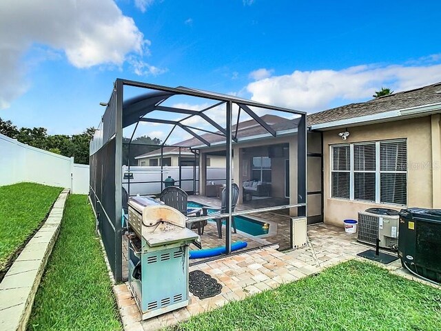 exterior space with a fenced in pool, glass enclosure, a fenced backyard, and central air condition unit