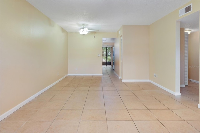 tiled spare room with a textured ceiling and ceiling fan