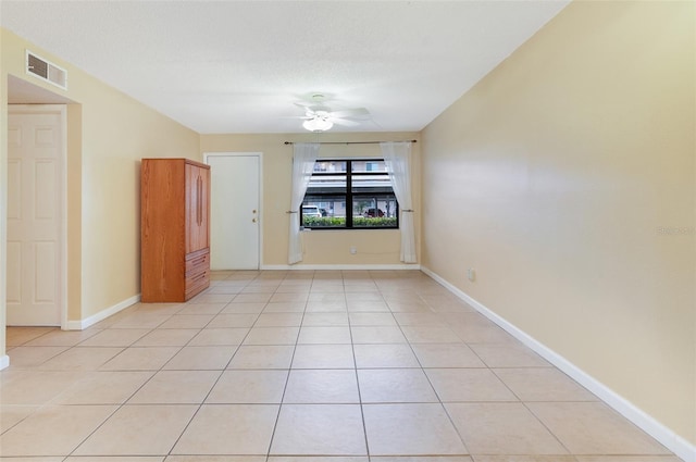 empty room featuring ceiling fan and light tile patterned floors