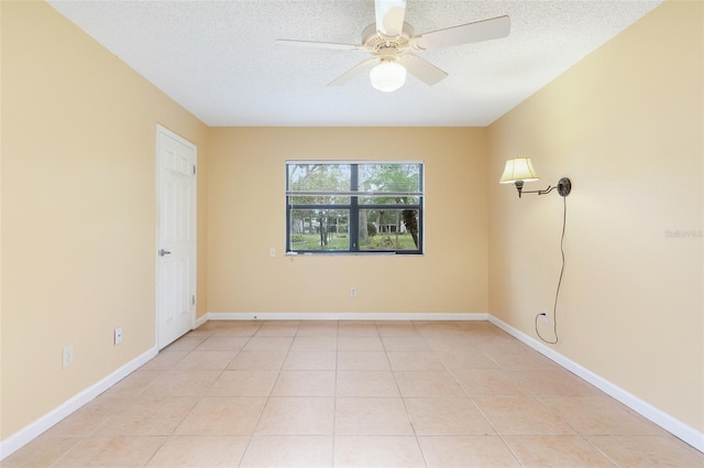 spare room featuring light tile patterned floors, a textured ceiling, and ceiling fan