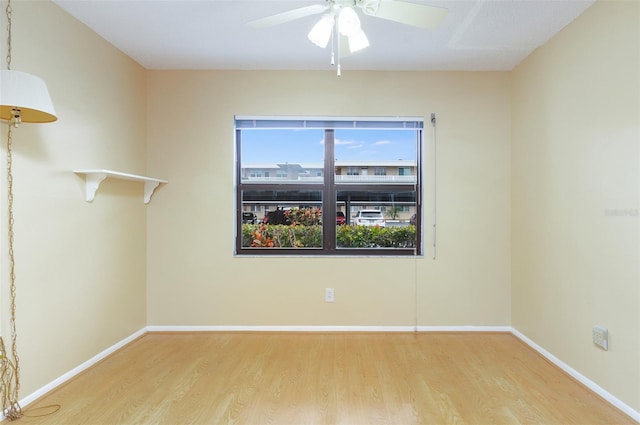 spare room with light wood-type flooring and ceiling fan