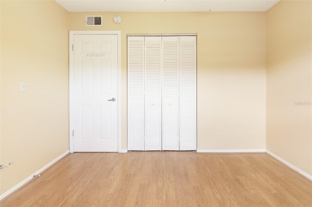 unfurnished bedroom featuring light hardwood / wood-style floors and a closet