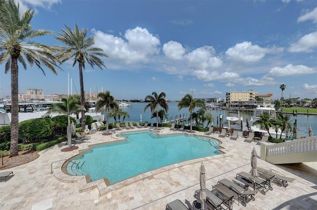 view of pool with a water view and a patio