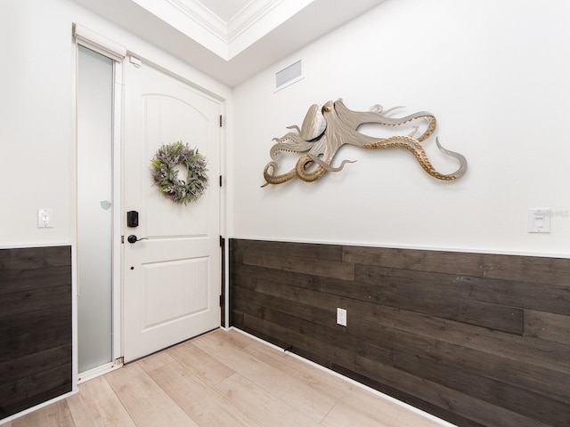 doorway to outside with light wood-type flooring and ornamental molding