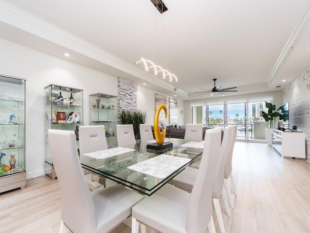 dining space with a tray ceiling, ceiling fan, light hardwood / wood-style flooring, and crown molding