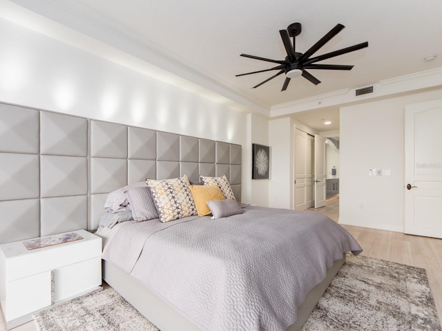 bedroom featuring light hardwood / wood-style floors, ceiling fan, and ornamental molding