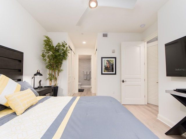 bedroom with light wood-type flooring and ensuite bathroom