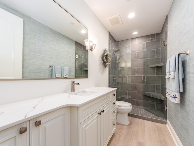 bathroom featuring vanity, hardwood / wood-style flooring, toilet, and an enclosed shower