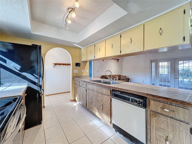 kitchen with dishwasher, sink, a raised ceiling, stainless steel range with electric stovetop, and light tile patterned floors