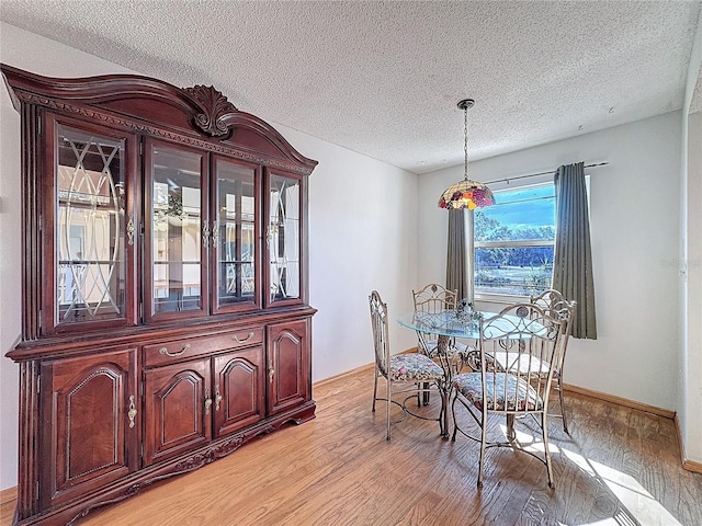 dining area featuring light hardwood / wood-style floors and a textured ceiling