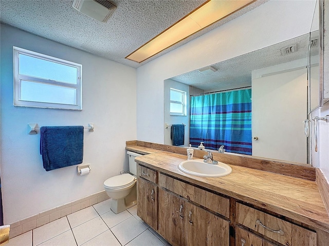 bathroom with tile patterned floors, vanity, toilet, and a textured ceiling