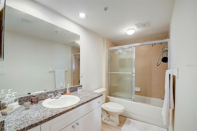 full bathroom with vanity, toilet, and bath / shower combo with glass door