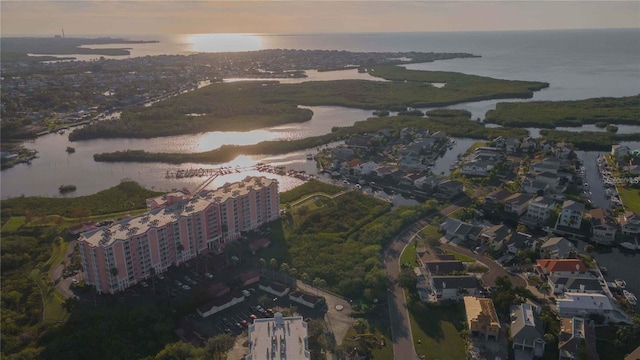 aerial view at dusk featuring a water view