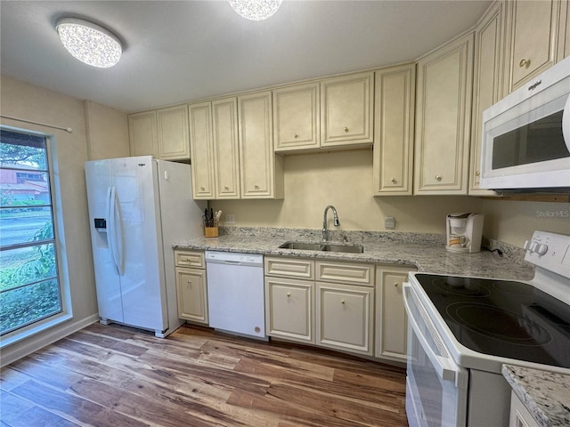 kitchen featuring cream cabinetry, white appliances, and sink