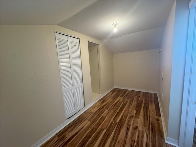 additional living space with dark hardwood / wood-style flooring and vaulted ceiling