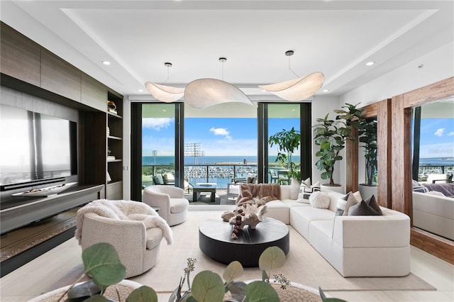 living room featuring built in shelves, floor to ceiling windows, and a water view