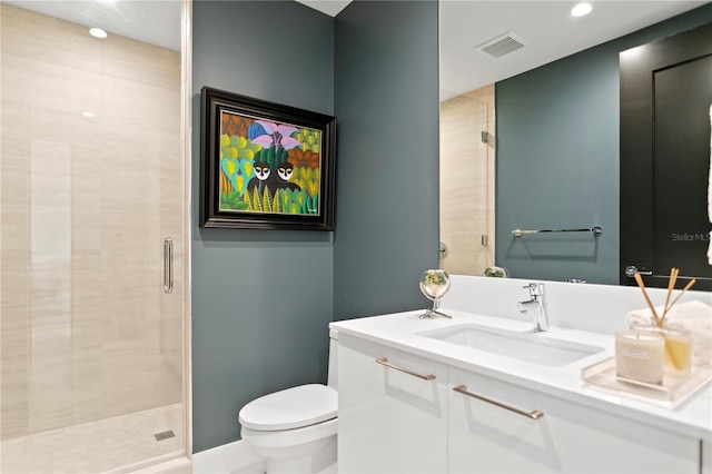 bathroom with vanity, toilet, and a shower with door