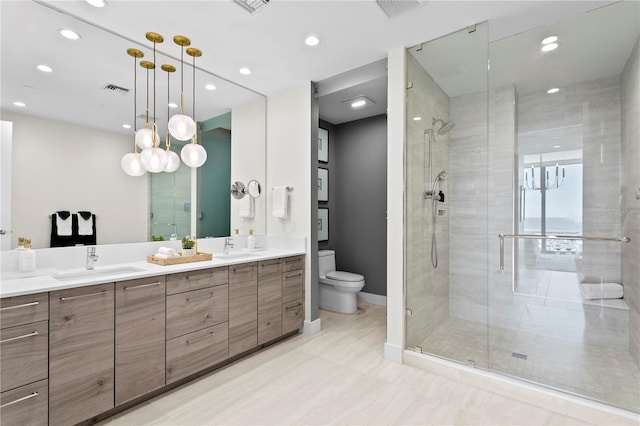 bathroom featuring vanity, toilet, and a shower with door