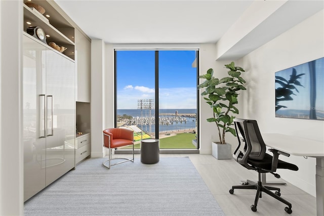 home office with a water view, plenty of natural light, and floor to ceiling windows