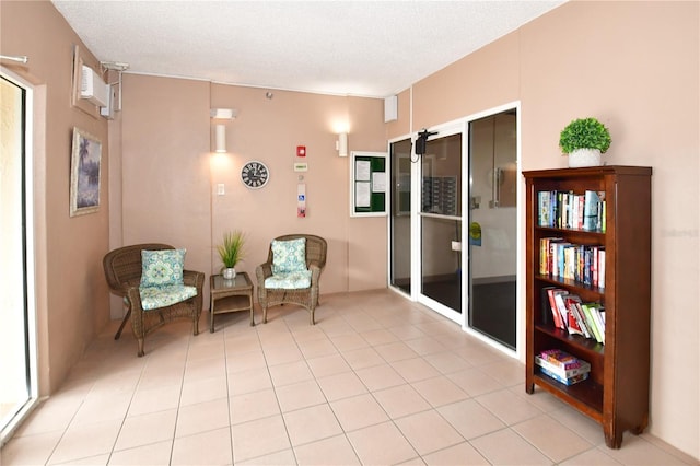 living area with a textured ceiling and light tile patterned flooring