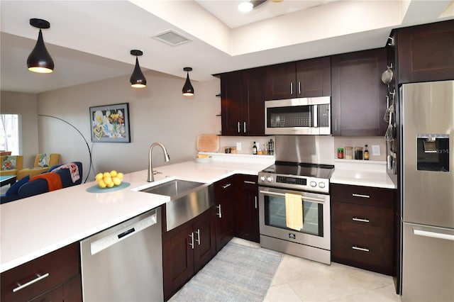 kitchen with sink, hanging light fixtures, kitchen peninsula, dark brown cabinets, and appliances with stainless steel finishes