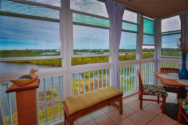 sunroom / solarium featuring a water view