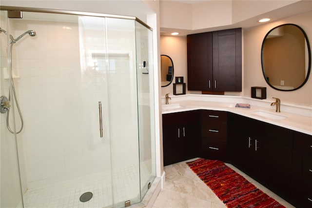 bathroom featuring a shower with door and vanity