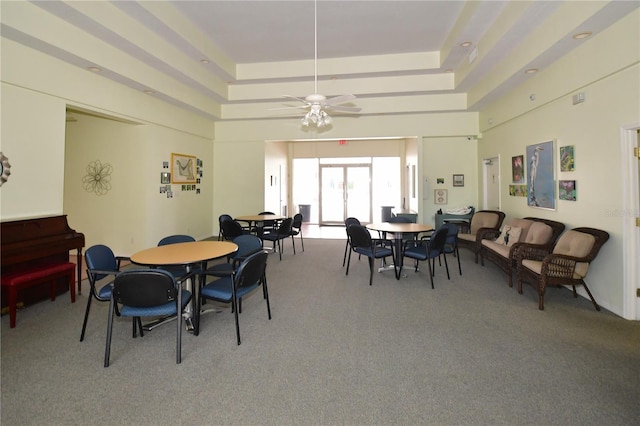 carpeted dining area featuring ceiling fan and a tray ceiling