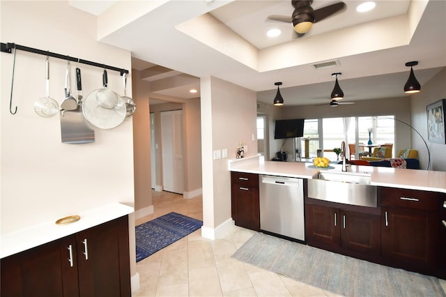 kitchen featuring sink, stainless steel dishwasher, light tile patterned floors, ceiling fan, and a raised ceiling