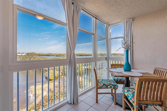 sunroom featuring a water view