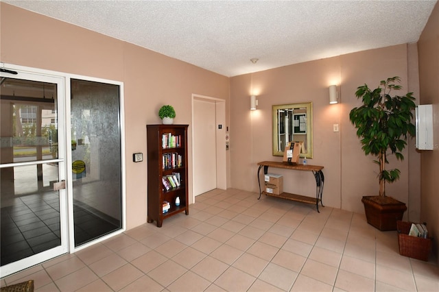 tiled entrance foyer featuring a textured ceiling