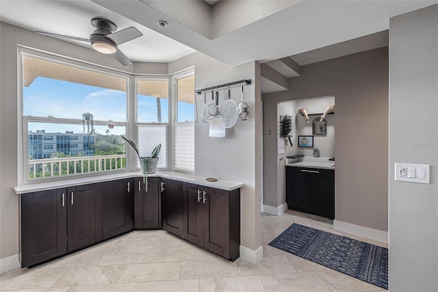 kitchen featuring ceiling fan, dark brown cabinetry, and light tile patterned floors