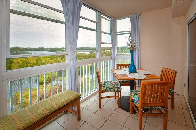 sunroom featuring a healthy amount of sunlight and a water view